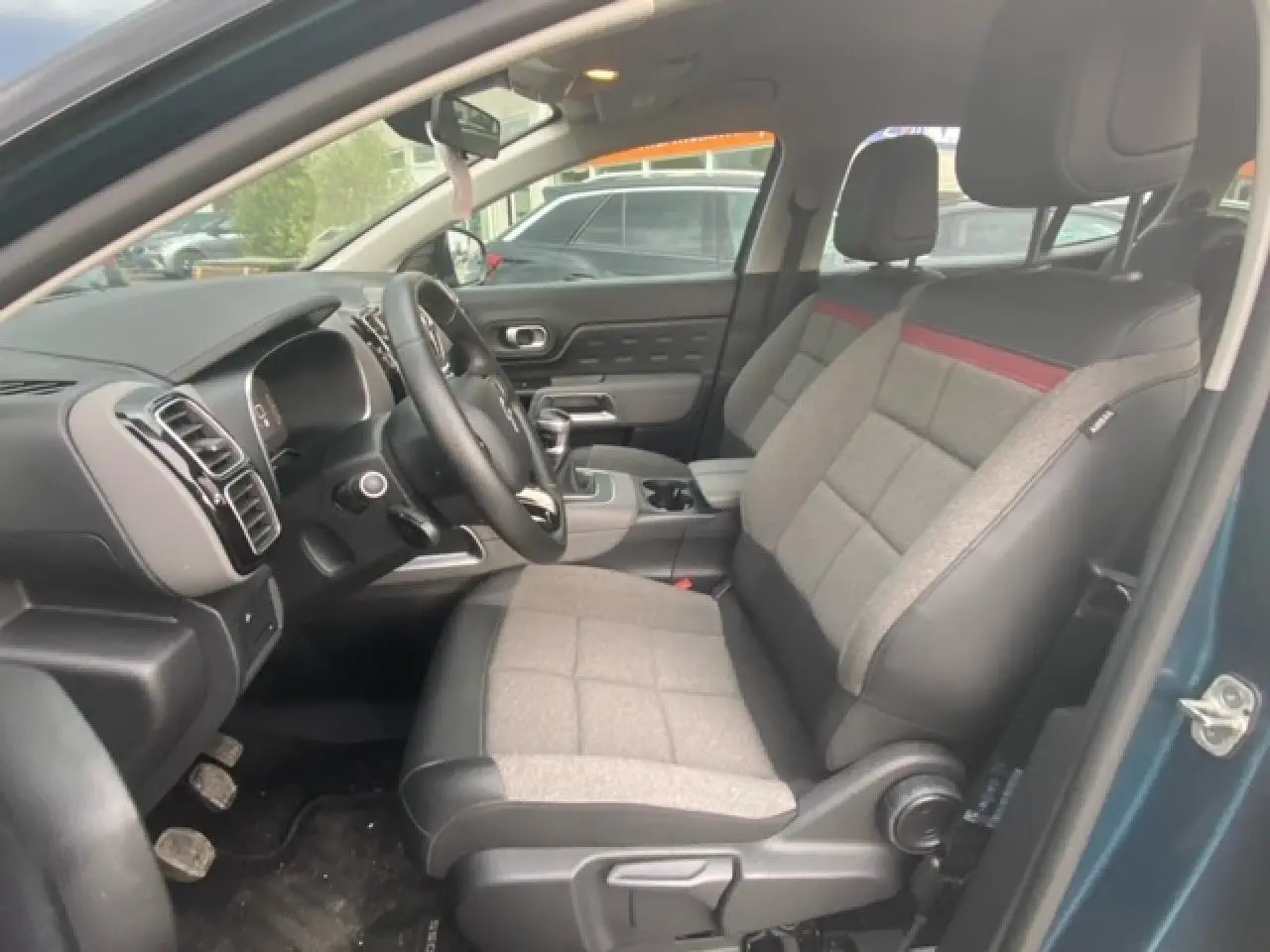 Vue intérieure côté conducteur du Citroën C5 Aircross 2021 bleu, sièges tissu et cuir gris avec bande rouge.