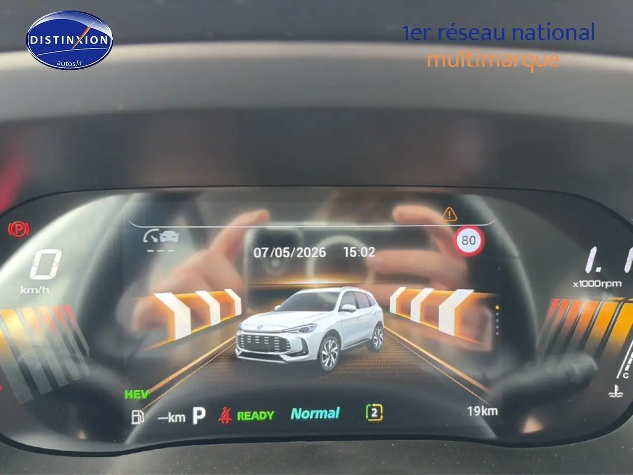 Affichage numérique du tableau de bord montrant une MG ZS grise en vue 3/4 avant avec indications de conduite.