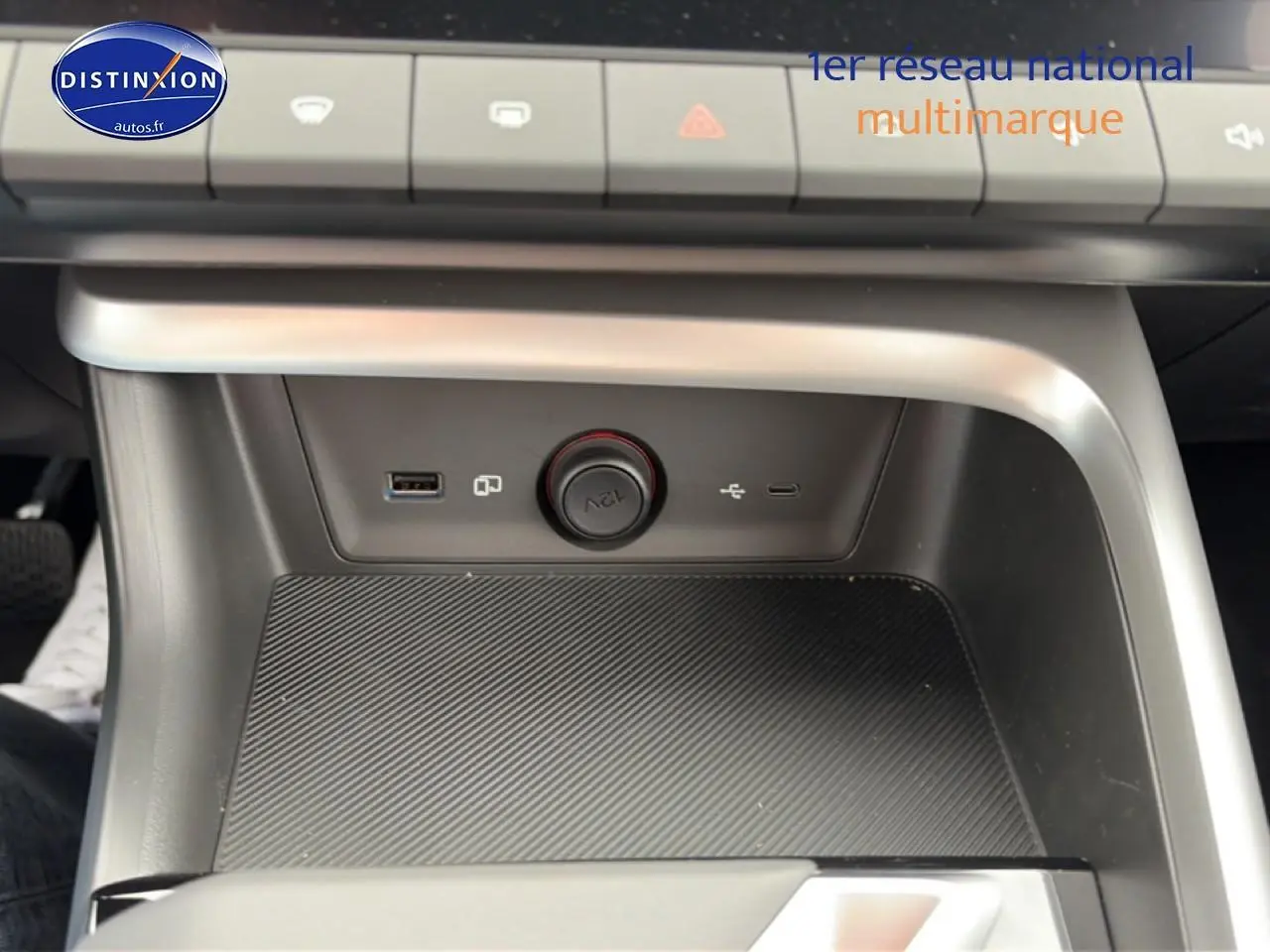 Vue rapprochée de la console centrale grise du MG ZS Hybrid 197 avec prises USB et allume-cigare 12V.