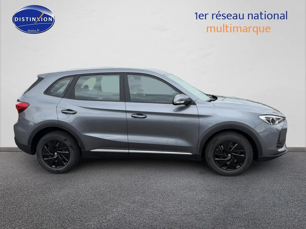 Vue de profil côté gauche du MG ZS Hybrid gris avec jantes noires et rétroviseurs argentés sur fond neutre.