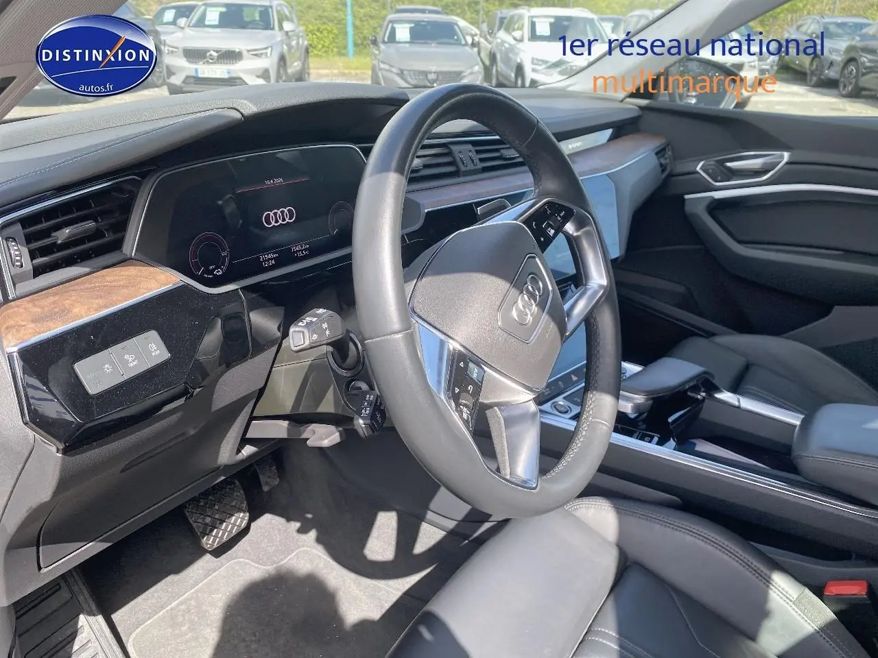Vue intérieure côté conducteur de l'Audi Q8 E-TRON 55 408 avus quattro 2022, volant cuir et tableau de bord numérique.