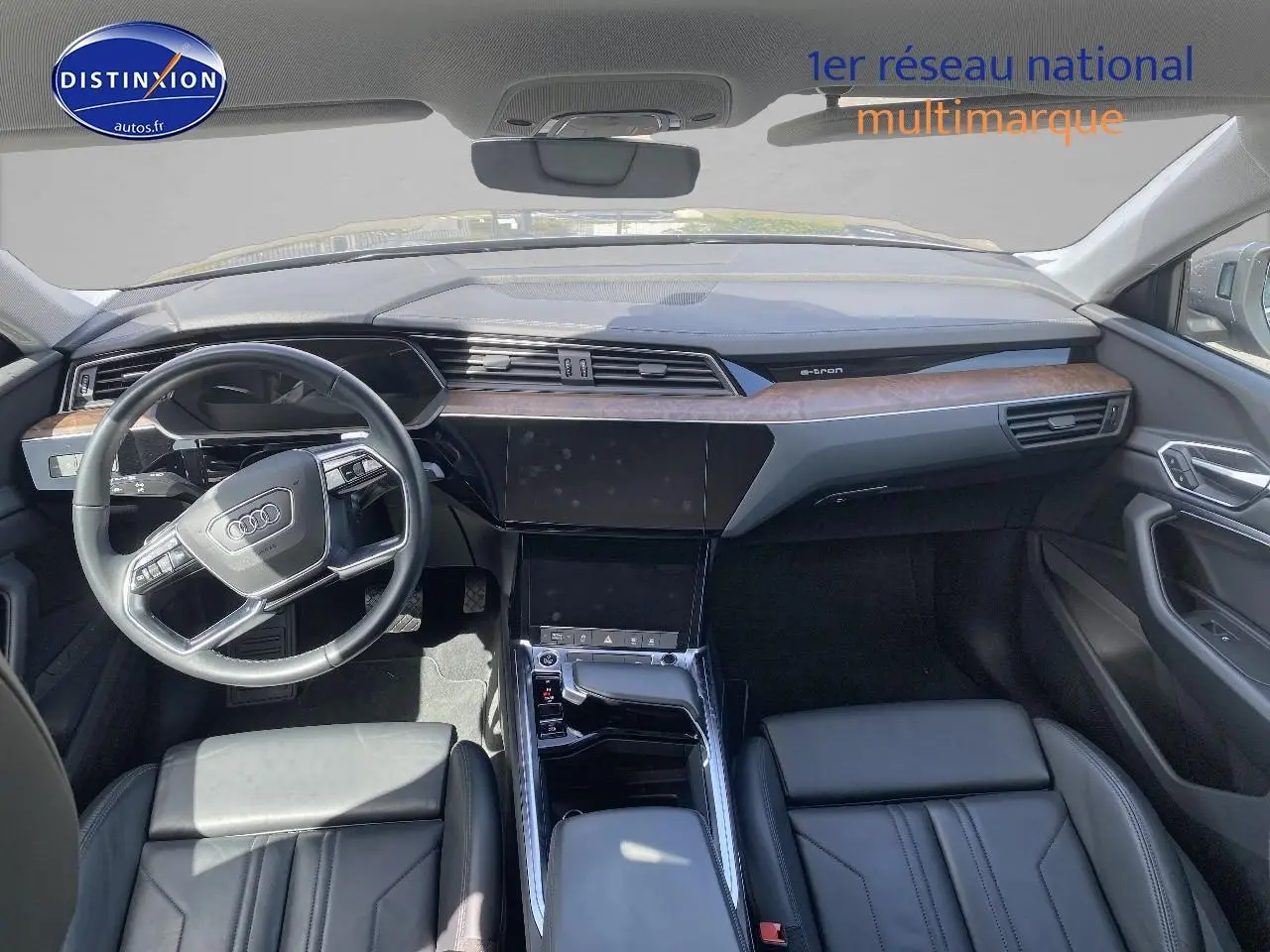 Vue intérieure avant de l'Audi Q8 E-TRON 55 408 avus quattro 2022 avec tableau de bord bois et cuir noir.