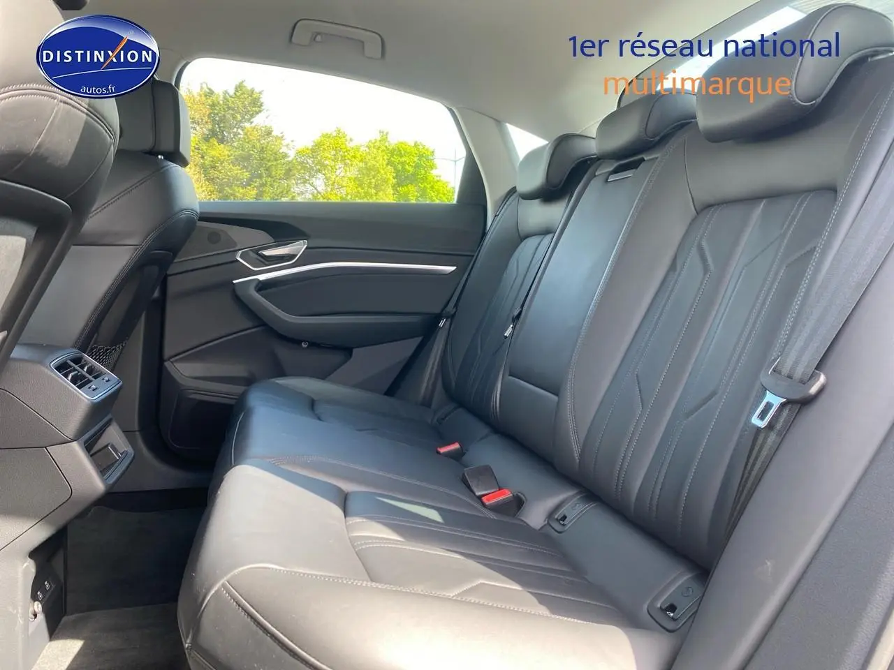 Vue latérale droite des sièges arrière en cuir noir de l'Audi Q8 E-Tron gris, avec ceintures et appuie-têtes visibles.
