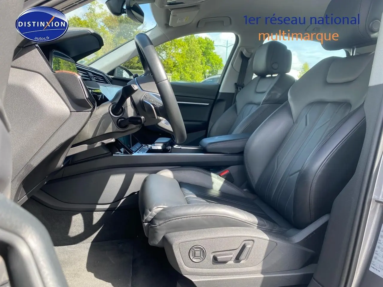 Intérieur avant droit de l’Audi Q8 E-Tron gris 2022 avec sièges sport cuir noir et tableau de bord moderne.