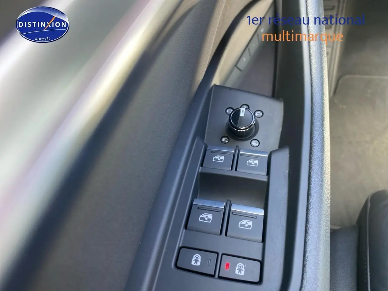 Gros plan sur les commandes de lève-vitres et rétroviseurs côté conducteur d’un Audi Q8 E-Tron gris.