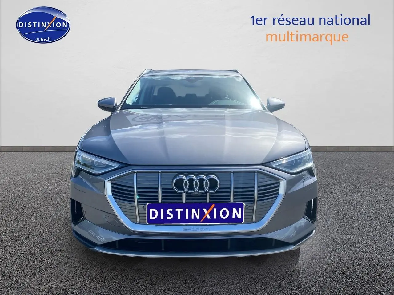 Audi Q8 E-Tron gris vue de face avec calandre large et logo Audi bien visible sur fond neutre.