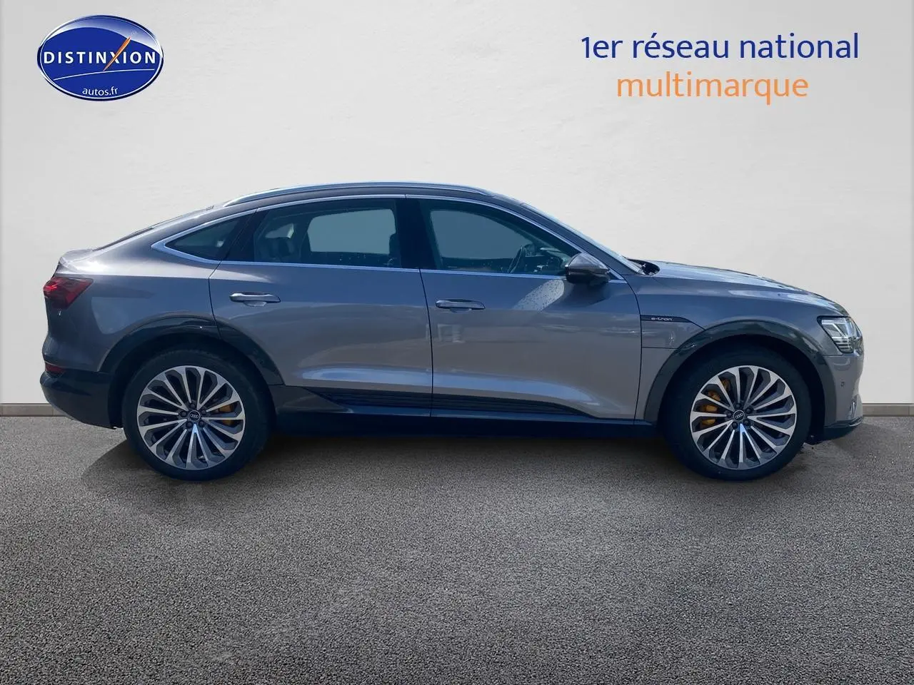Audi Q8 E-Tron gris en vue latérale droite, soulignant ses jantes alu et sa silhouette élancée électrique.