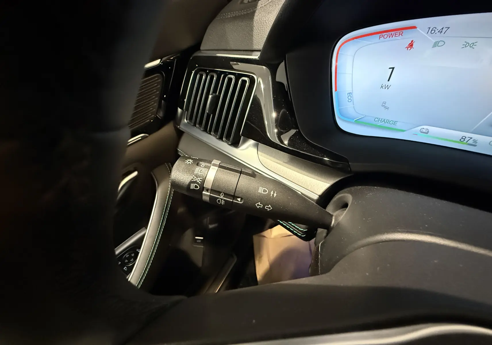 Gros plan sur la commande de clignotant et l'écran digital bleu du tableau de bord intérieur du BYD SEAL U gris.