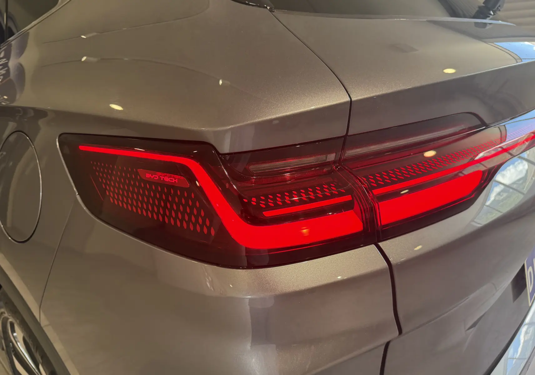 Feu arrière droit allumé du BYD SEAL U gris, vue rapprochée soulignant le design LED et la texture intérieure du feu.