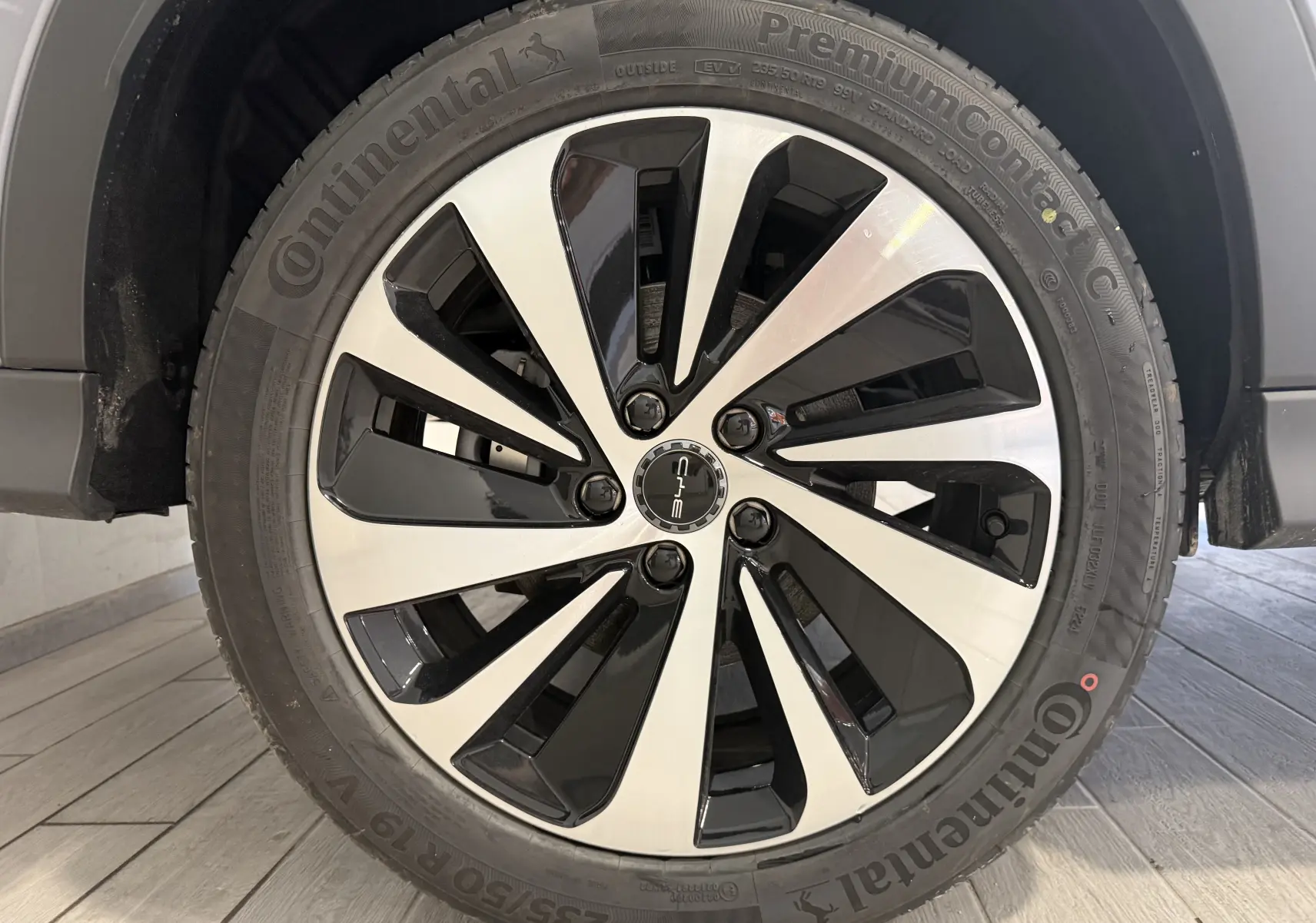 Gros plan sur la jante bicolore noir et argent du BYD SEAL U gris, mettant en valeur le logo central et le pneu Continental.