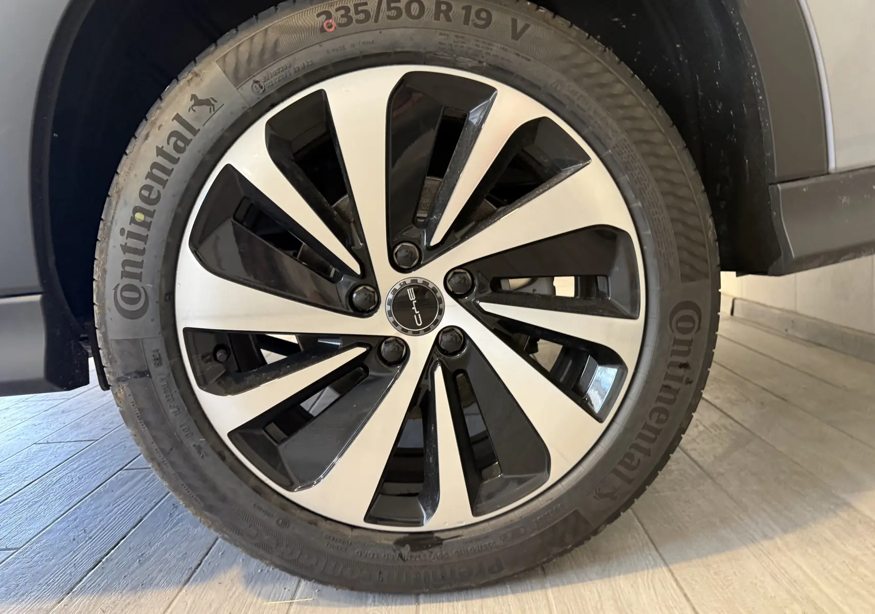Gros plan sur la jante bi-ton noire et argent du côté gauche d’un BYD SEAL U gris, avec pneu Continental visible.