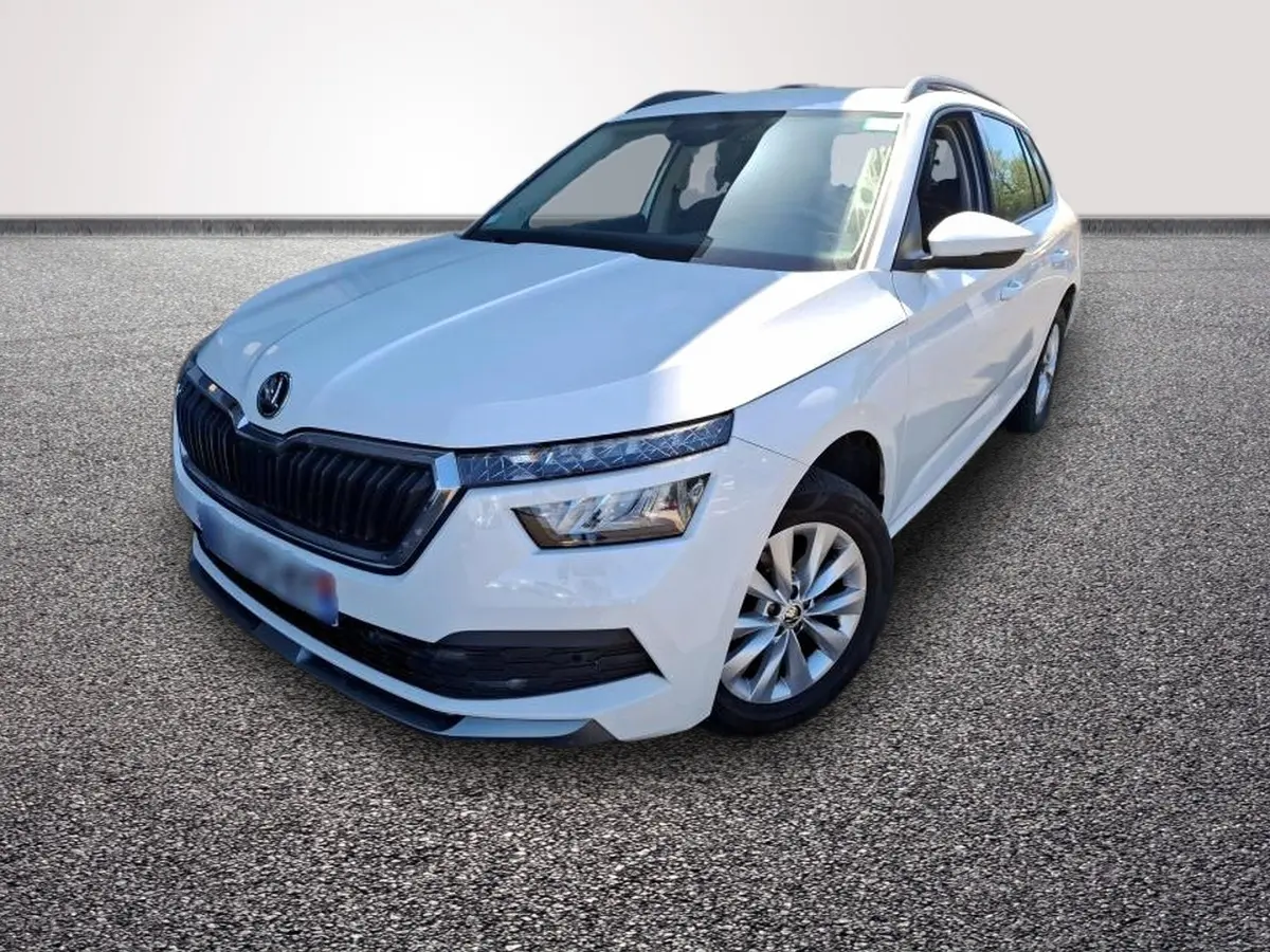 Vue 3/4 avant droite d'un Skoda Kamiq blanc avec calandre noire et jantes alliage argentées.