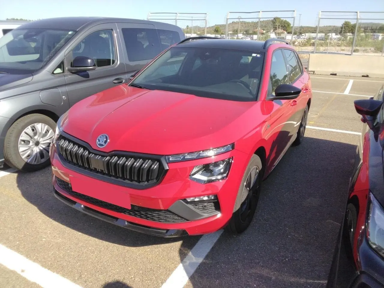 Vue 3/4 avant droite d'un Skoda Kamiq Monte-Carlo rouge Velvet avec toit panoramique et jantes alliage noires.