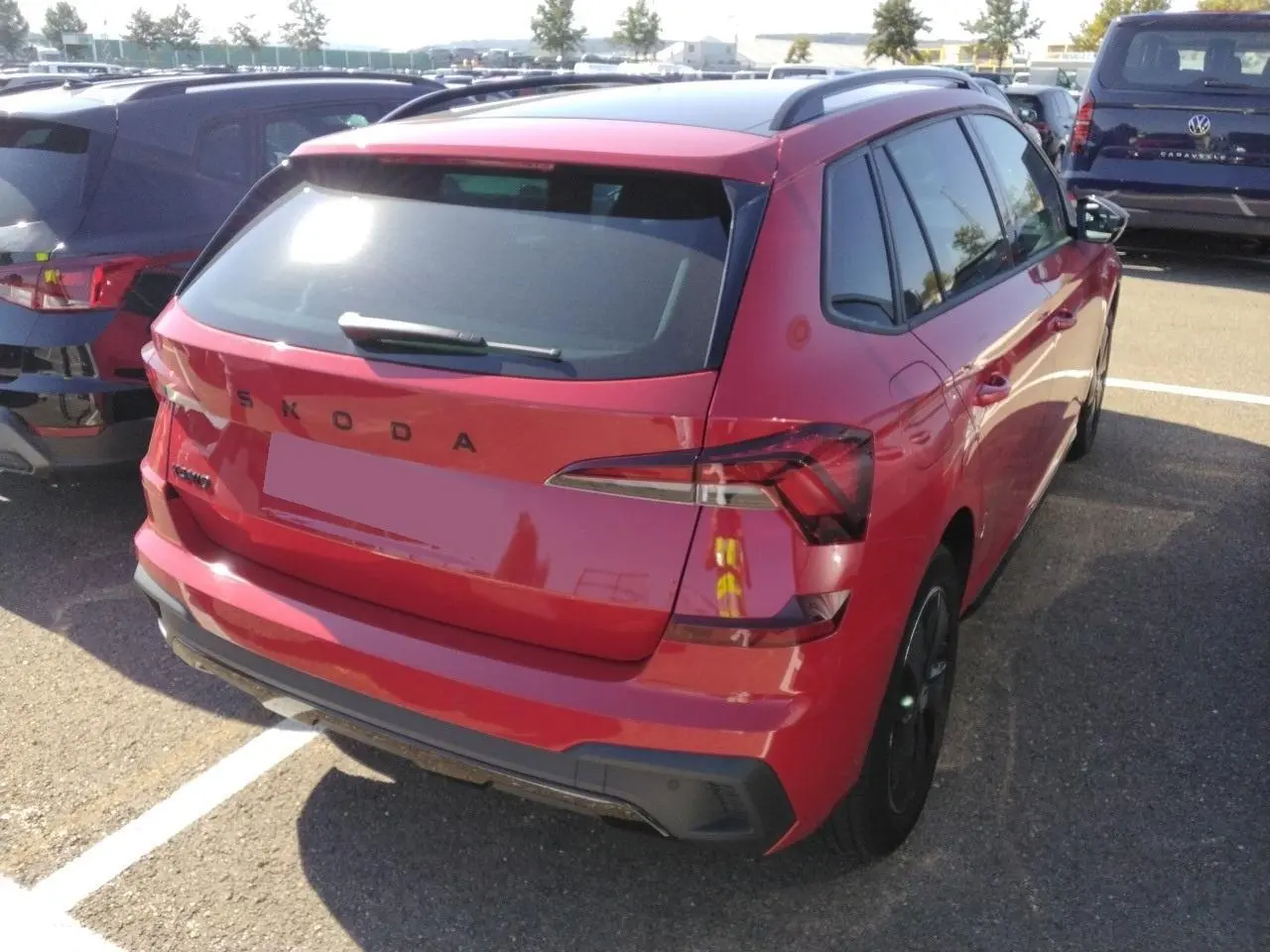 Vue 3/4 arrière droite d'un Skoda Kamiq Monte-Carlo rouge Velvet avec hayon électrique et toit panoramique.