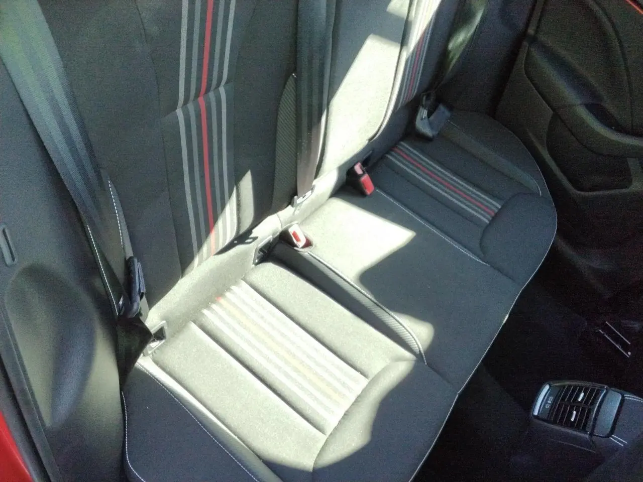 Vue plongeante sur la banquette arrière noire avec bandes grises et rouge du Skoda Kamiq Monte-Carlo 2025.
