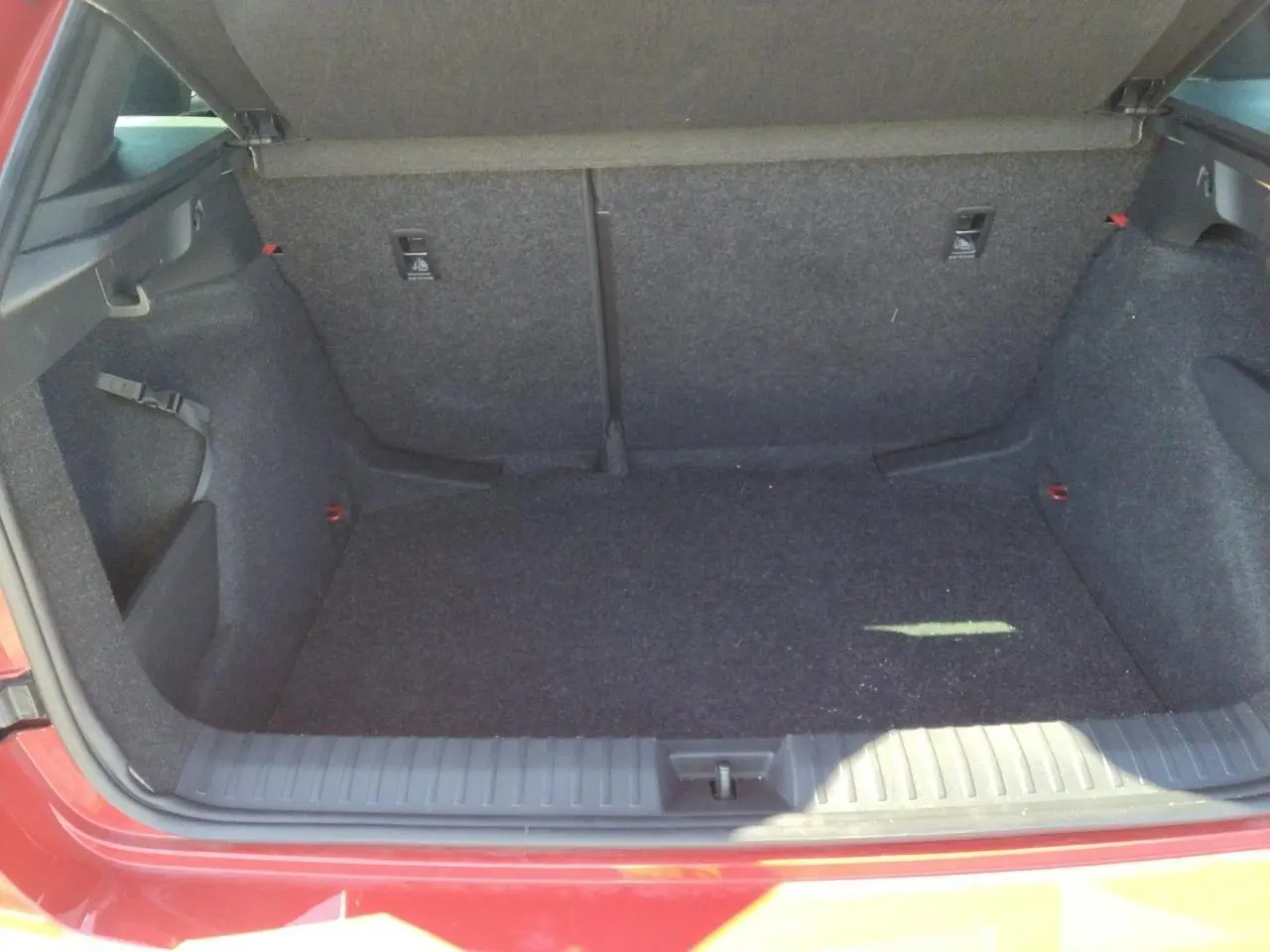 Coffre ouvert d'un Skoda Kamiq Rouge Velvet, vue arrière mettant en valeur l'espace de chargement et le hayon électrique.