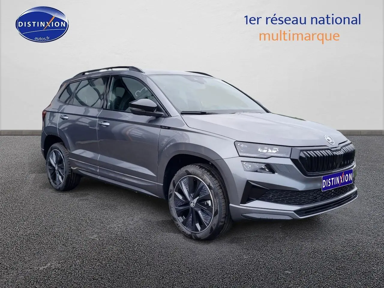 Vue 3/4 avant droite du SUV SKODA KAROQ gris graphite 2025 avec jantes alliage et calandre noire sportive.