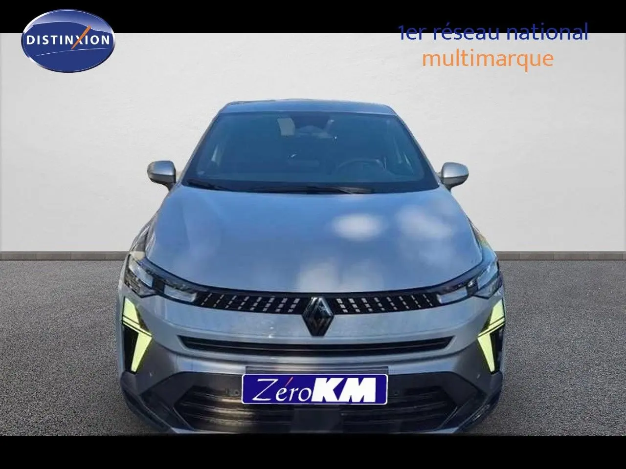 Vue avant du Renault Captur E-Tech hybride gris Rafale métal avec feux diurnes LED allumés sur fond neutre.