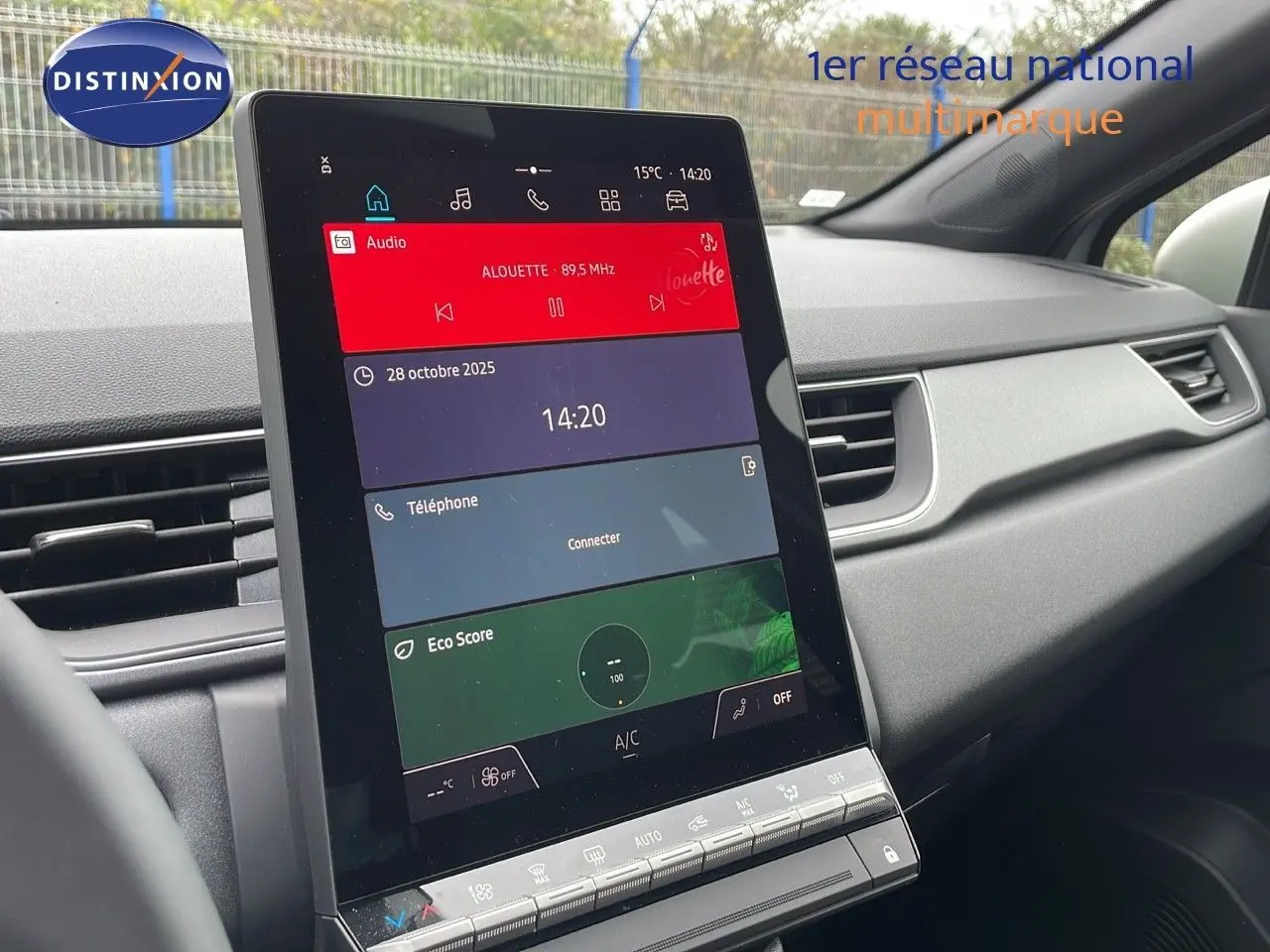 Vue intérieure centrée sur l'écran tactile vertical du tableau de bord du Renault Captur gris Rafale 2025.
