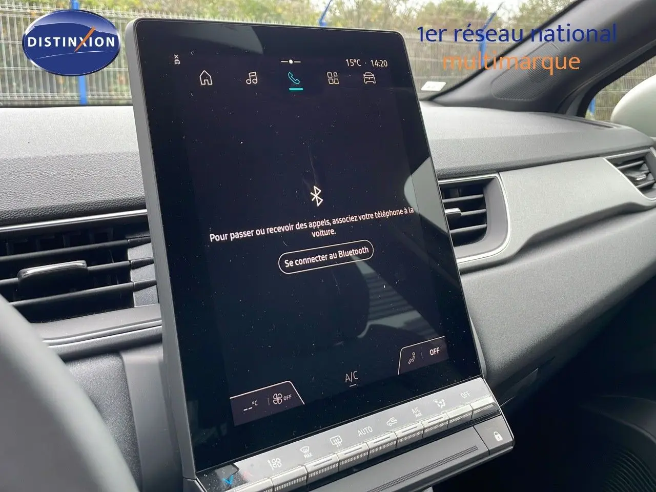 Vue intérieure centrée sur l'écran tactile vertical du tableau de bord du Renault Captur gris rafale métal.