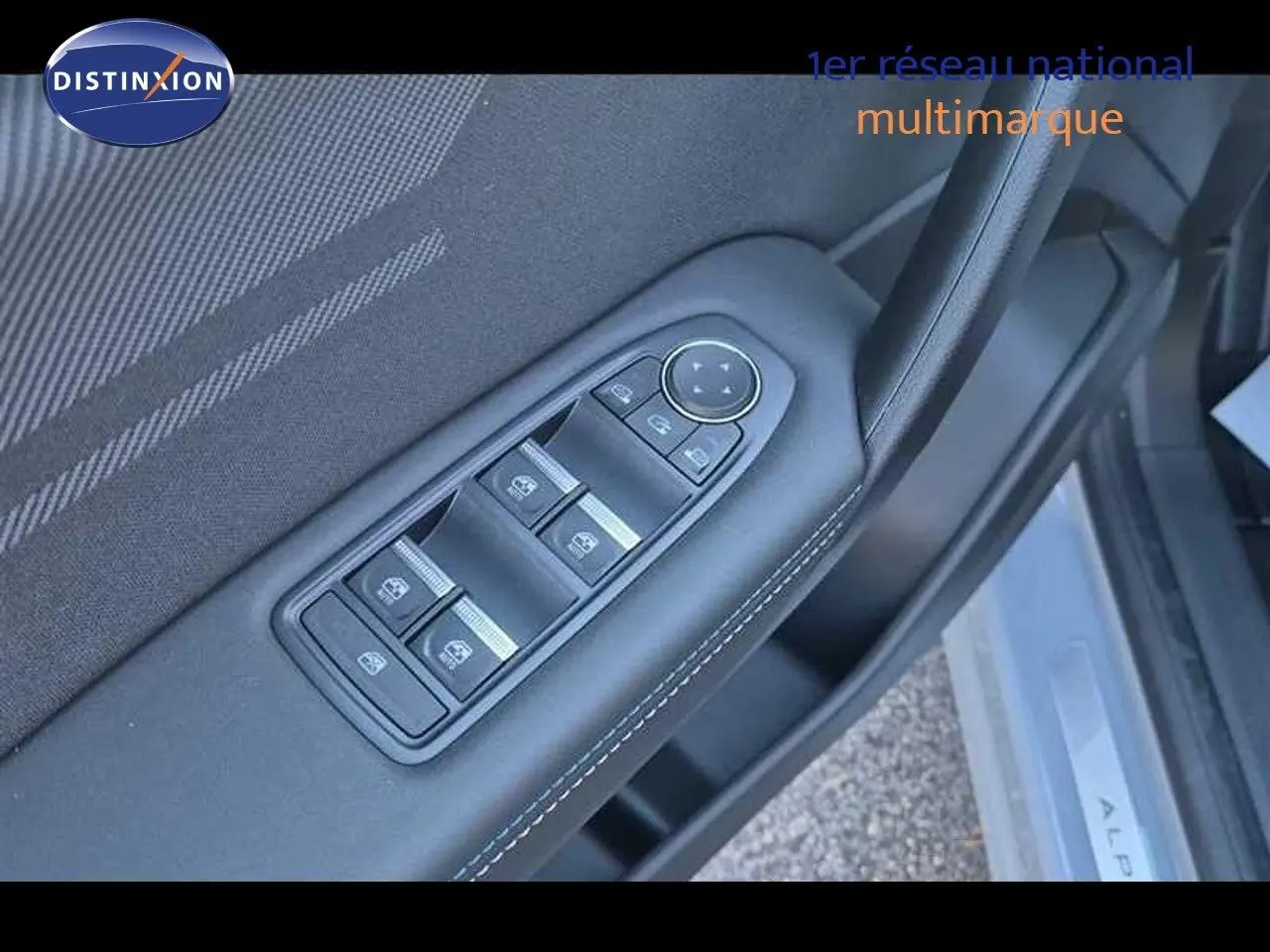 Gros plan sur les commandes des vitres électriques et rétroviseurs sur la porte côté conducteur d’un Renault Captur gris Rafale.