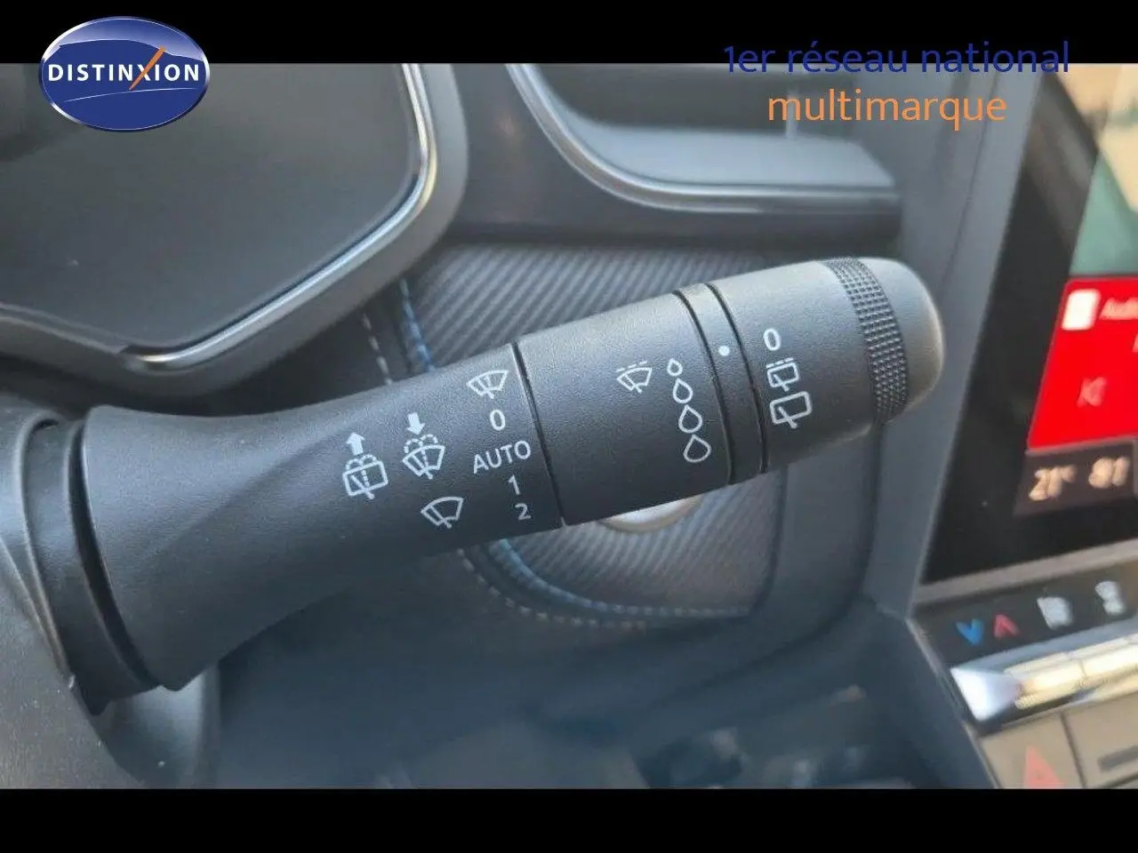 Gros plan sur la commande d’essuie-glace du Renault Captur gris Rafale, intérieur avec détails de la console tactile.