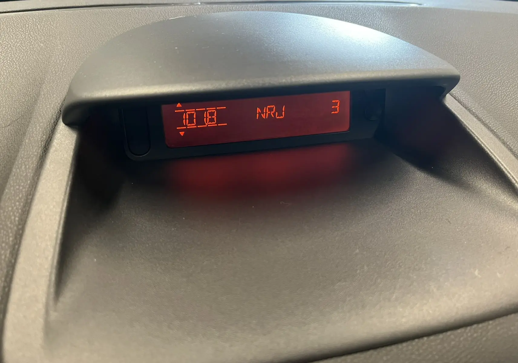 Affichage central rouge du système audio de la Renault Clio III RS 20th Anniversary, vue rapprochée du tableau de bord.