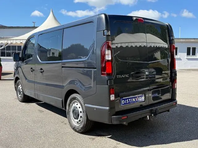 Vue 3/4 arrière droite d’un Renault Trafic cabine approfondie gris comète avec portes arrière battantes et plaque Distinxion.