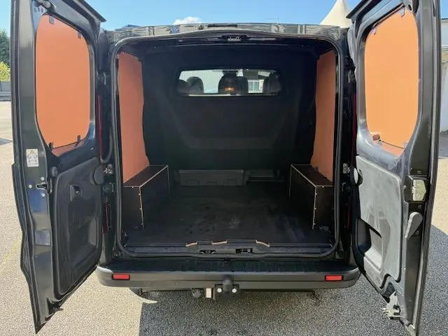Vue arrière ouverte du Renault Trafic Cabine Approfondie gris comète, montrant l’intérieur avec habillage bois et plancher antidérapant.