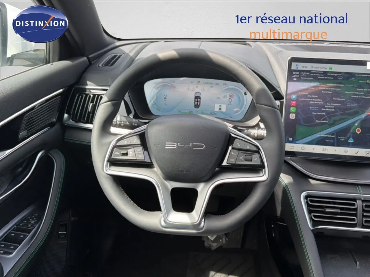 Vue intérieure centrée sur le volant BYD du SEAL U blanc métal, avec tableau de bord numérique et écran tactile.