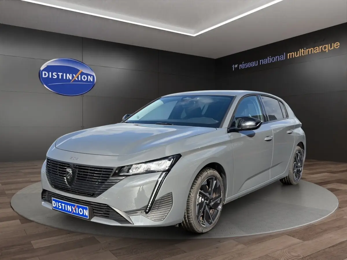 Peugeot 308 Hybrid gris foncé vue 3/4 avant droite, avec calandre noire et phares LED distinctifs.