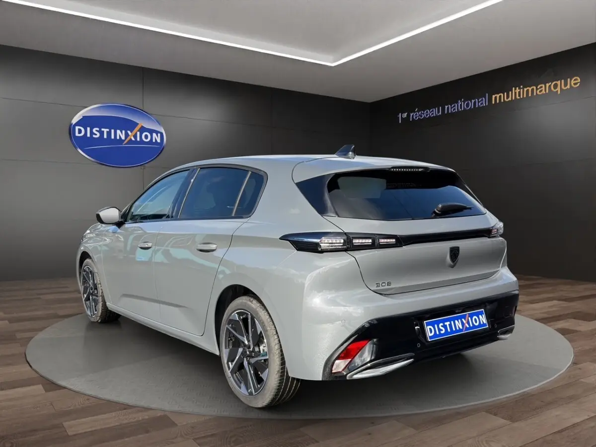 Vue 3/4 arrière droite d'une Peugeot 308 gris foncé avec feux LED et jantes alliage modernes.