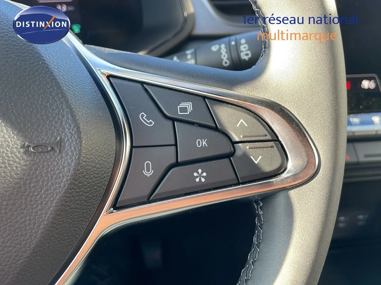 Gros plan sur les commandes multifonctions au volant du Renault Captur gris Rafale métal avec toit noir, version E-Tech hybride.