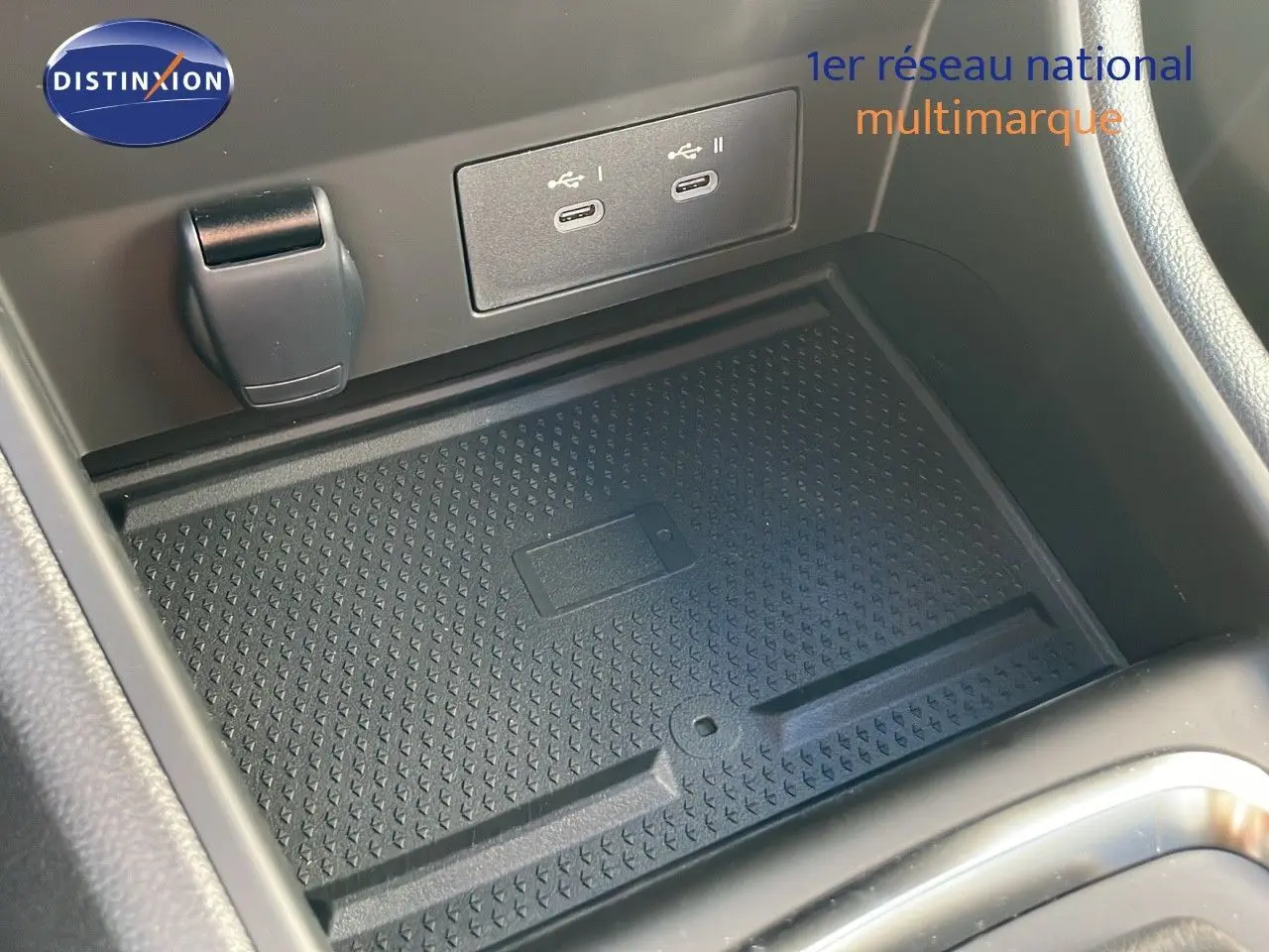 Gros plan sur la console centrale du Renault Captur 2025 montrant un espace de charge sans fil avec ports USB-C.