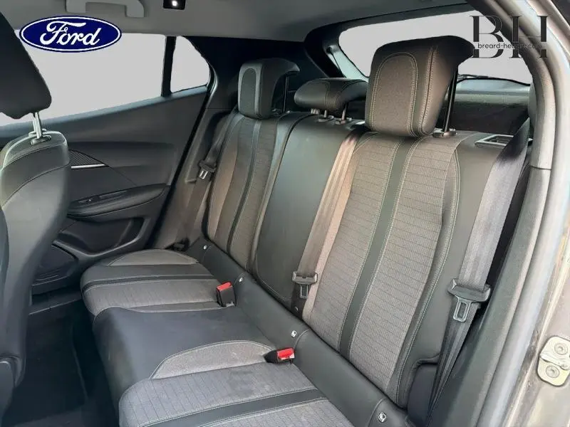 Vue intérieure du siège arrière d'une Peugeot 2008 gris Artense, montrant les appuie-têtes et ceintures de sécurité.