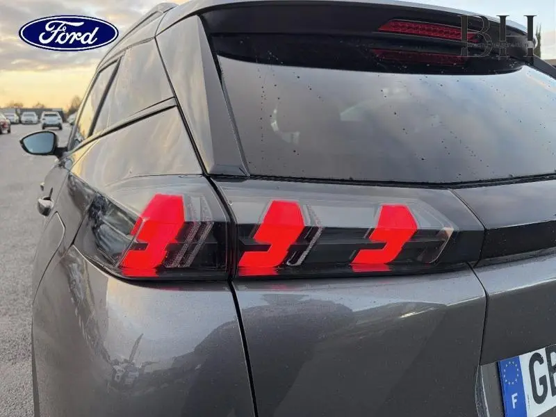 Gros plan sur le feu arrière gauche rouge d'un Peugeot 2008 gris Artense, soulignant son design anguleux et moderne.