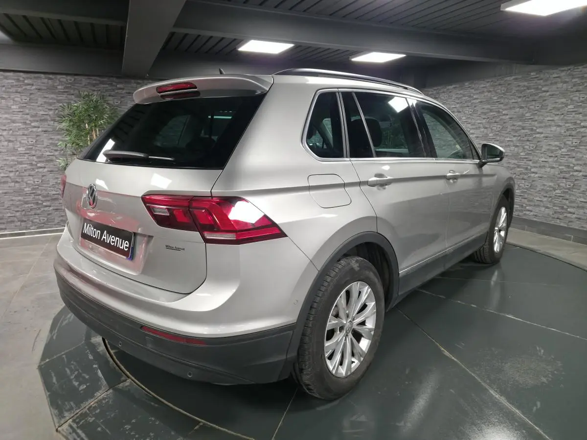 Volkswagen Tiguan gris métallisé vue 3/4 arrière droit en intérieur avec jantes alliage 17 pouces.