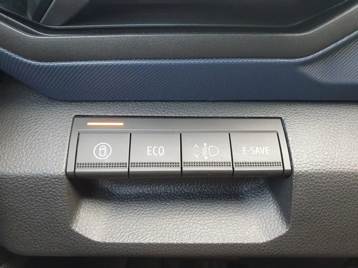 Gros plan sur les boutons de commande du tableau de bord du Dacia Duster 1.6 Hybrid 140, finition Journey+ Pack City.