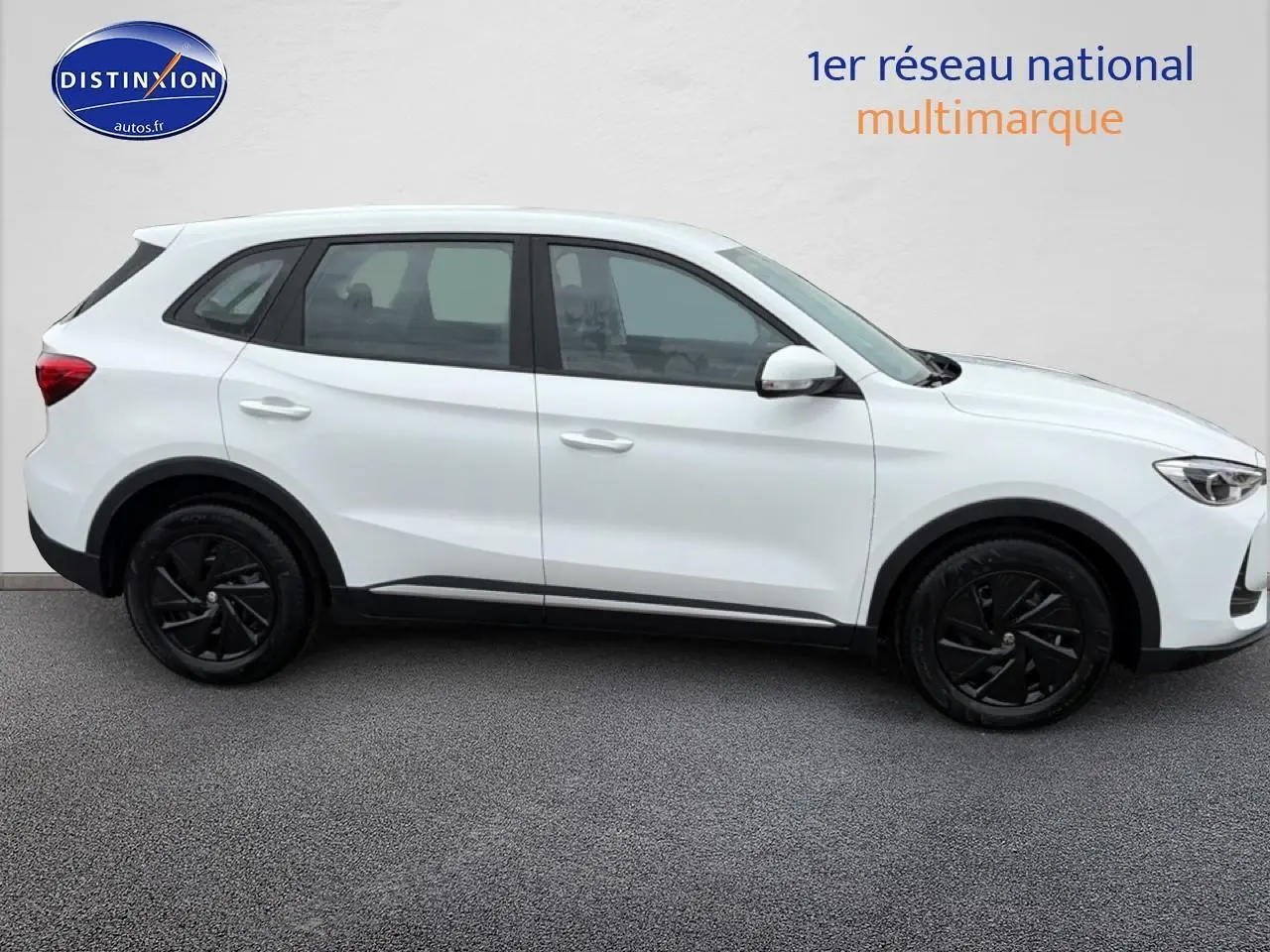 Vue de profil côté gauche d'un MG ZS Hybrid blanc avec jantes noires et lignes épurées sur fond neutre.