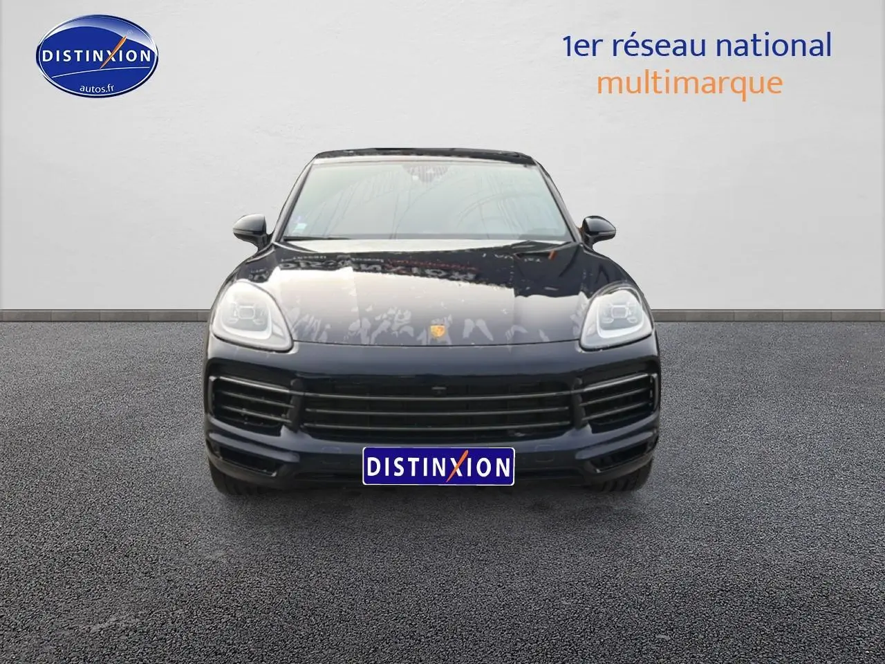 Vue frontale d'un Porsche Cayenne bleu foncé avec calandre large et phares LED distinctifs.