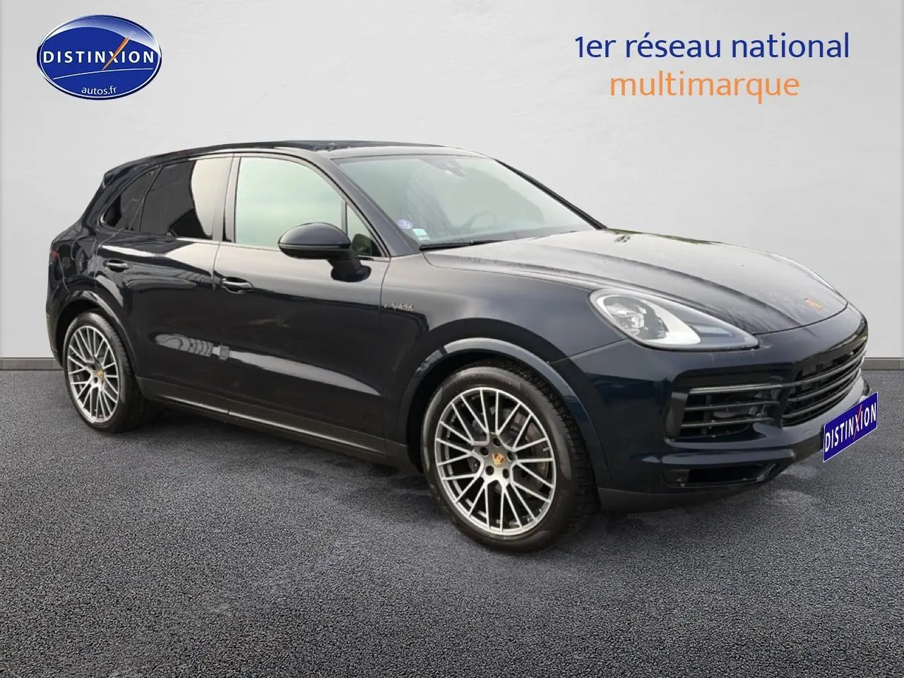 Vue 3/4 avant d’un Porsche Cayenne bleu foncé avec jantes alliage et vitres teintées.