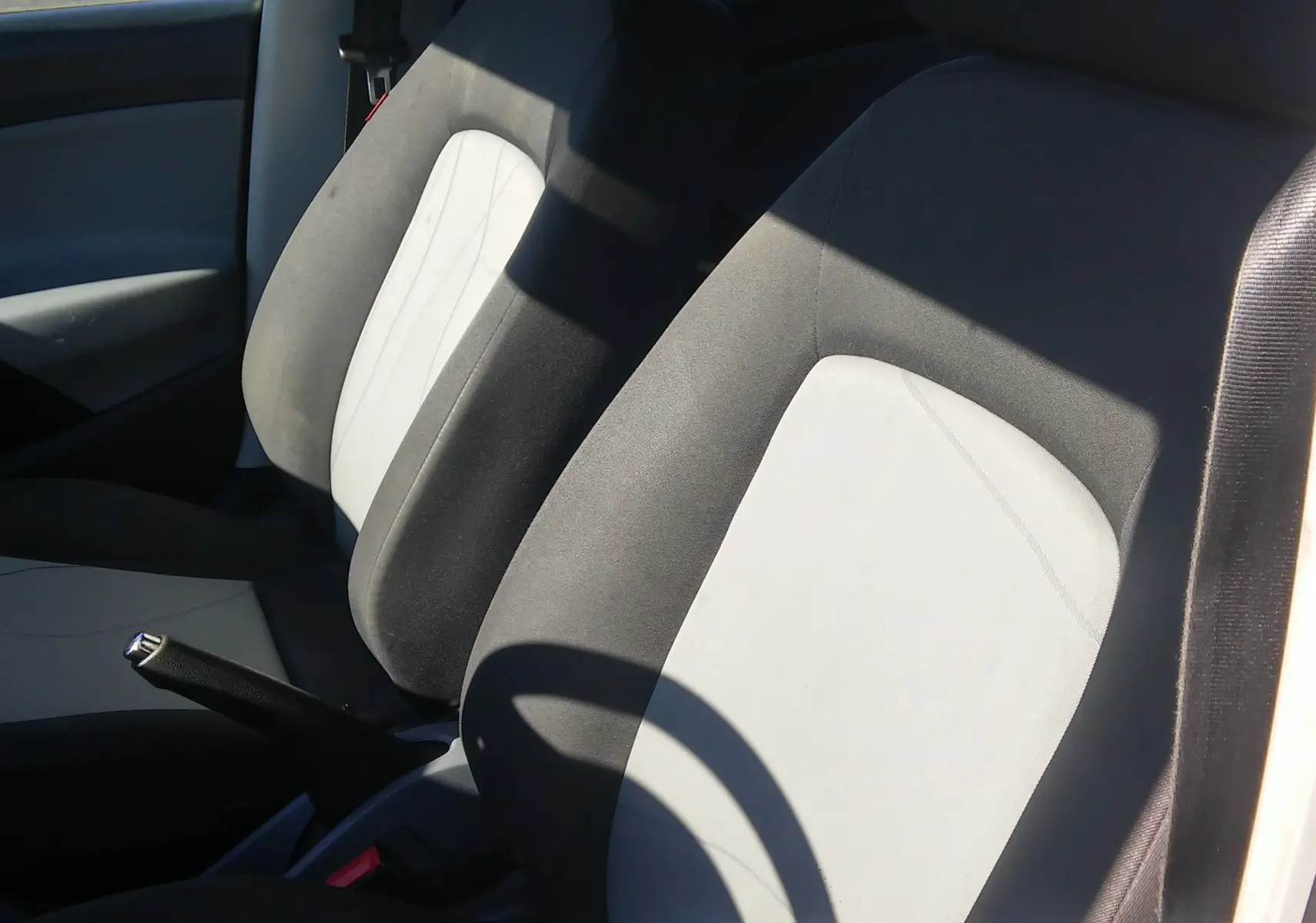 Gros plan sur les sièges avant gris clair et foncé de la SEAT Ibiza Business blanche, version diesel 2015.