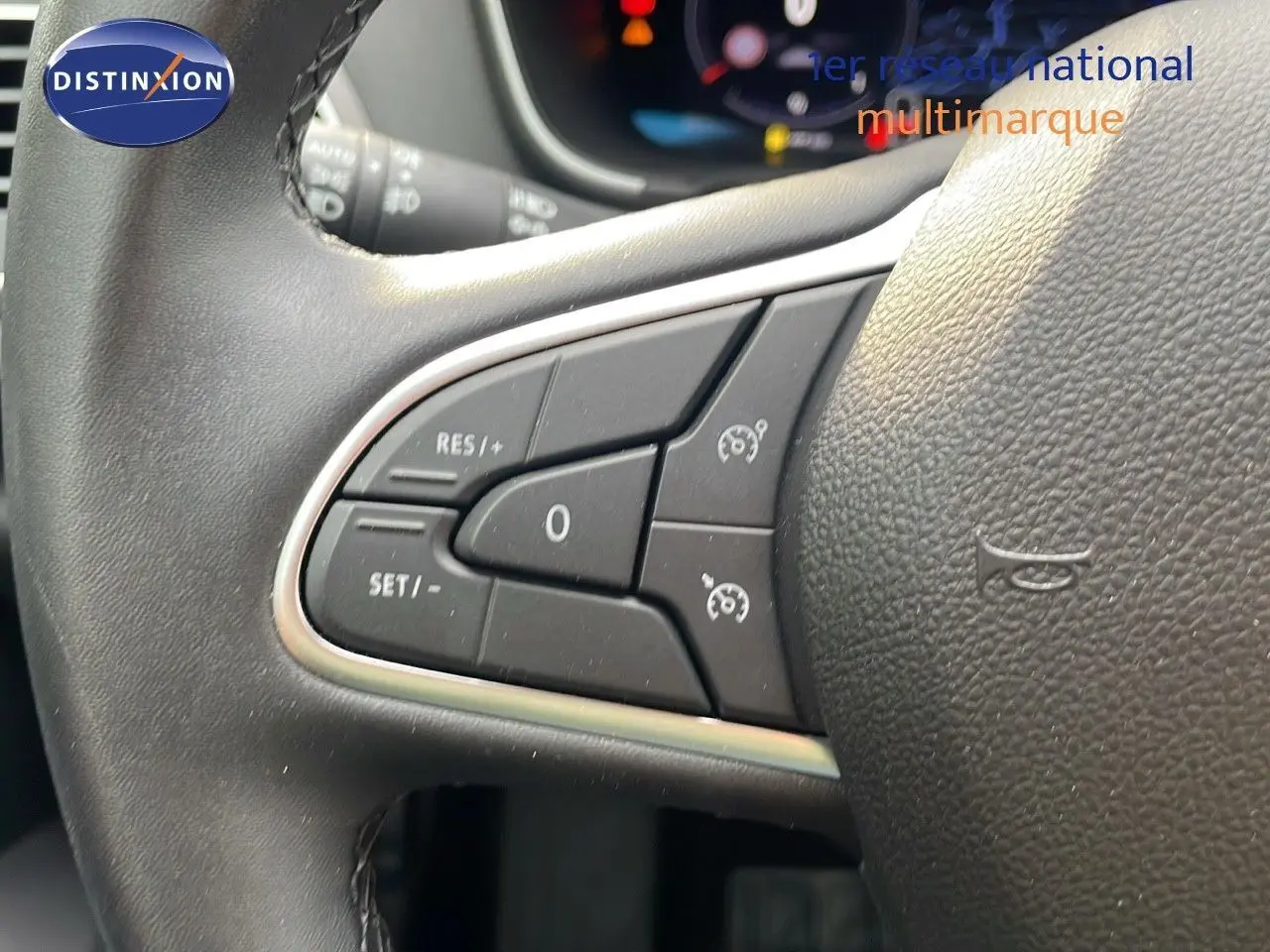 Gros plan sur les commandes de régulateur de vitesse au volant cuir noir d'une Renault Mégane Break gris Highland Metal 2024