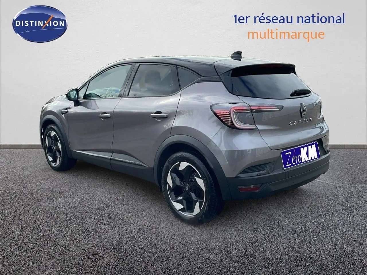 Renault Captur E-Tech hybride gris cassiopée avec toit noir, vue 3/4 arrière côté gauche, jantes bi-ton visibles.