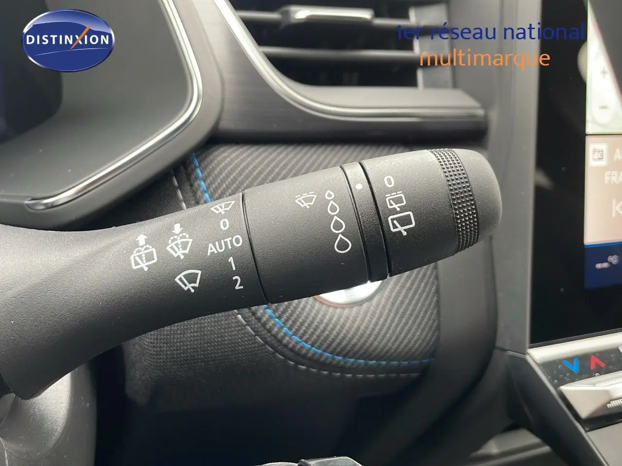 Gros plan sur la commande d'essuie-glace du Renault Symbioz gris Cassiopée, avec détails des réglages visibles sur fond carbone.