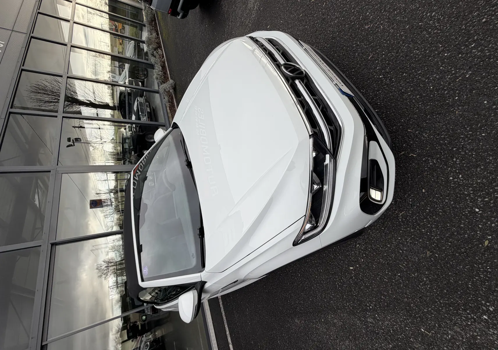 Vue 3/4 avant droit d'un Volkswagen T-Roc Cabriolet blanc 2022 avec calandre R-Line et toit ouvert.