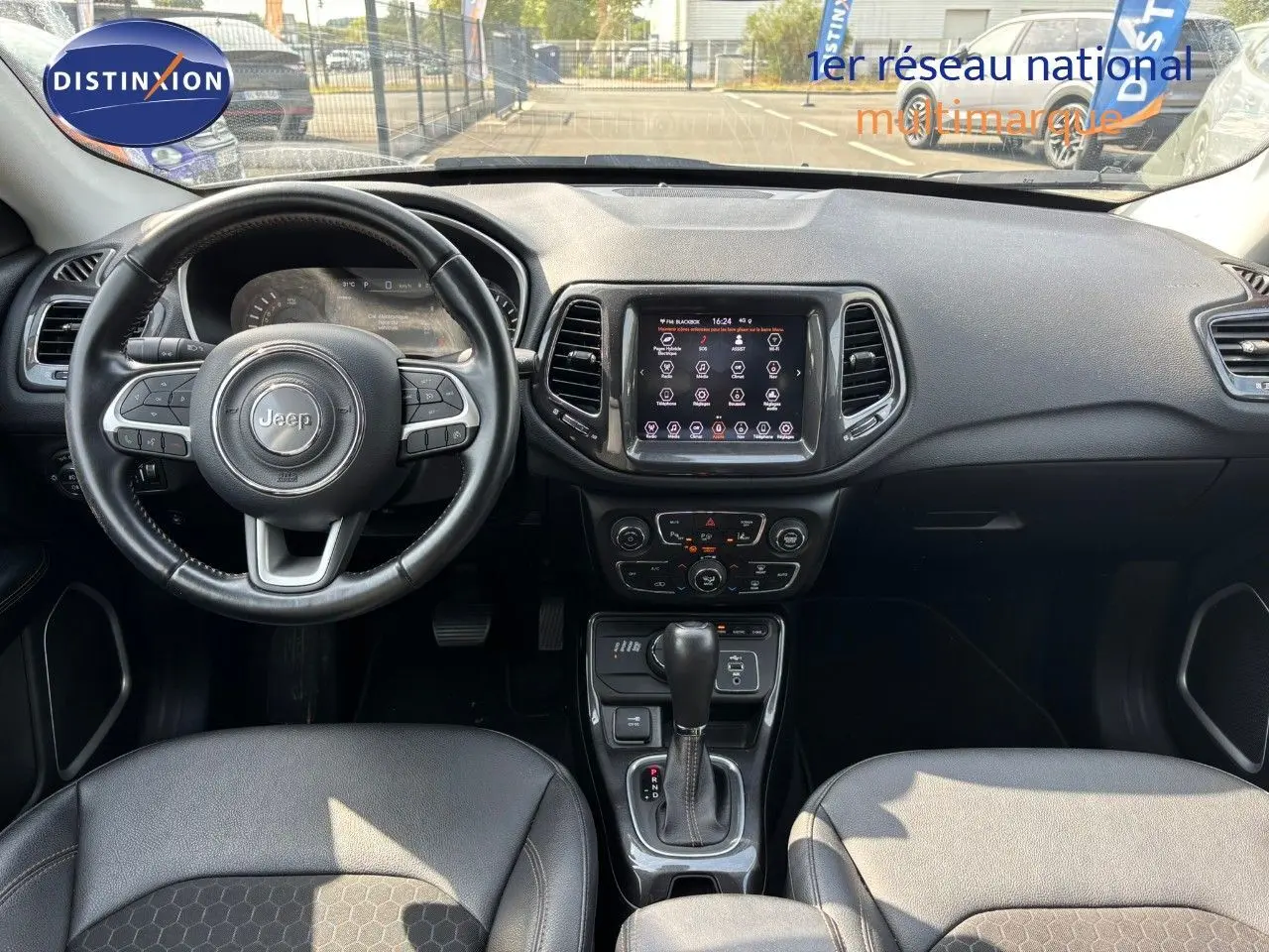 Vue intérieure du tableau de bord et volant du Jeep Compass 2021, avec écran tactile et sellerie cuir noire.