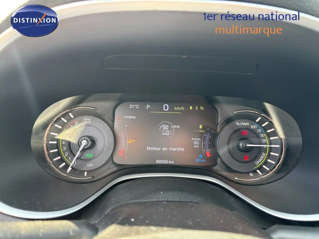 Vue rapprochée du tableau de bord numérique du Jeep Compass blanc, affichant les compteurs hybrides et la vitesse à 0 km/h.