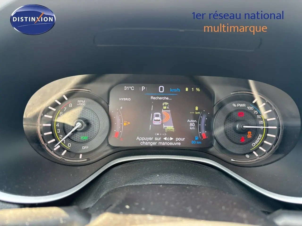 Vue rapprochée du tableau de bord numérique du Jeep Compass blanc hybride rechargeable, affichant les compteurs et informations de conduite.