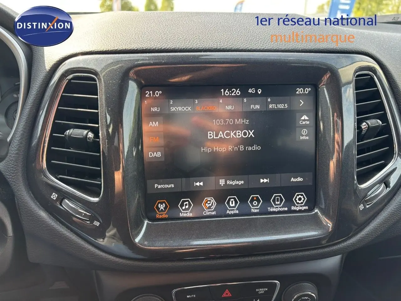Écran tactile central du tableau de bord du Jeep Compass blanc, affichant la radio FM sur station BLACKBOX.